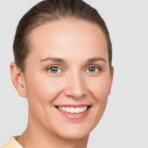 Joyful white young-adult female with short  brown hair and grey eyes