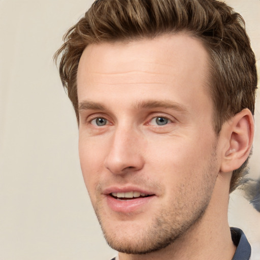 Joyful white young-adult male with short  brown hair and grey eyes