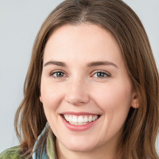 Joyful white young-adult female with medium  brown hair and green eyes