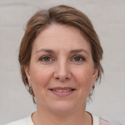 Joyful white adult female with medium  brown hair and grey eyes