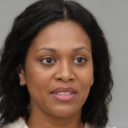 Joyful black young-adult female with medium  brown hair and brown eyes
