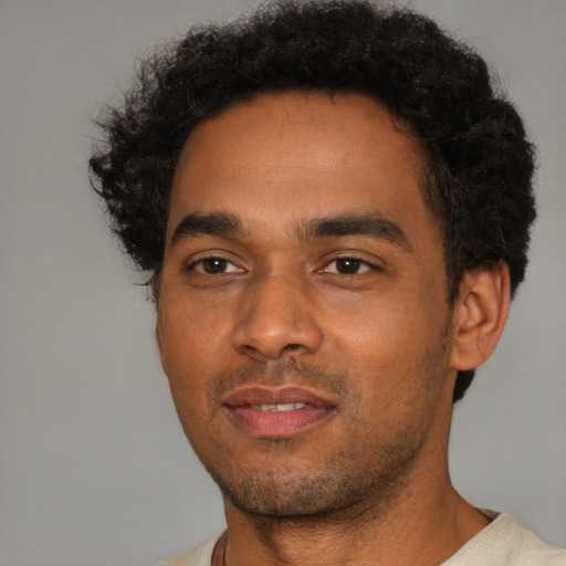 Joyful black young-adult male with short  black hair and brown eyes