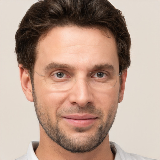 Joyful white adult male with short  brown hair and brown eyes