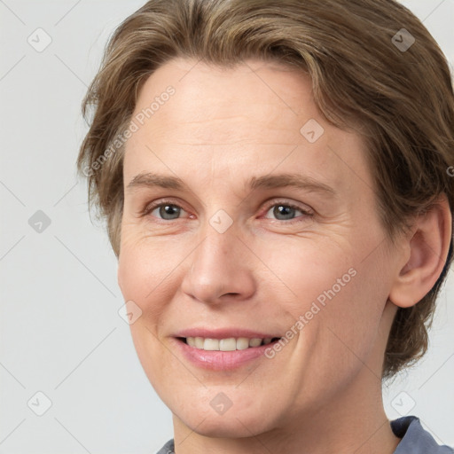 Joyful white adult female with medium  brown hair and grey eyes