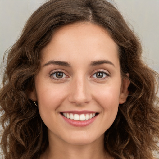 Joyful white young-adult female with long  brown hair and green eyes