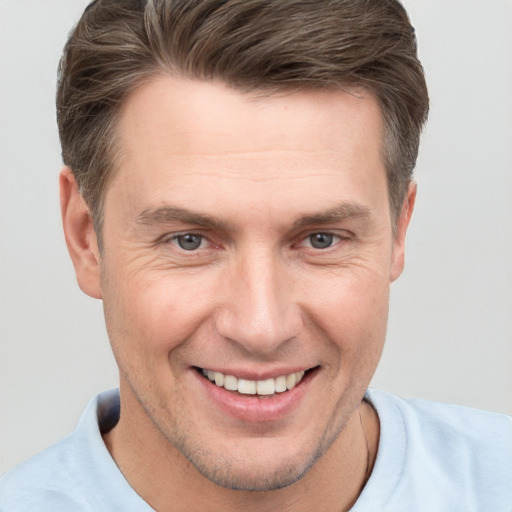 Joyful white adult male with short  brown hair and grey eyes