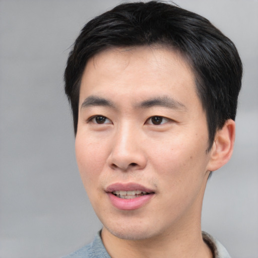 Joyful asian young-adult male with short  brown hair and brown eyes
