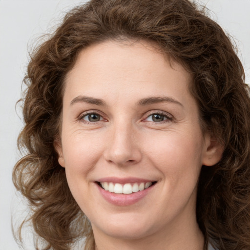 Joyful white young-adult female with long  brown hair and green eyes