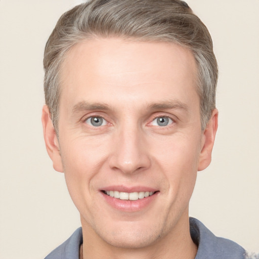 Joyful white adult male with short  brown hair and grey eyes