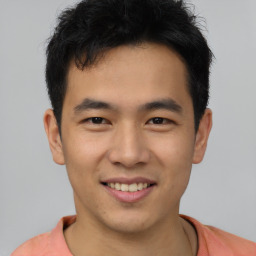 Joyful asian young-adult male with short  brown hair and brown eyes