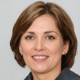 Joyful white adult female with medium  brown hair and grey eyes