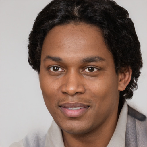 Joyful black young-adult male with short  brown hair and brown eyes