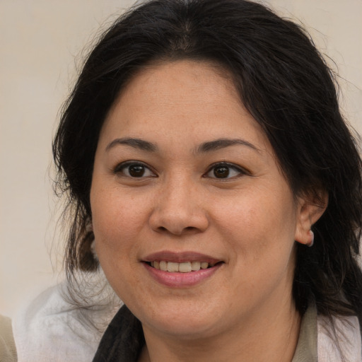 Joyful asian adult female with long  brown hair and brown eyes