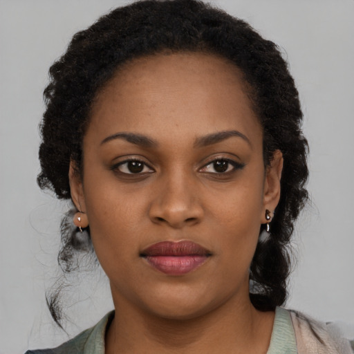Joyful black young-adult female with long  brown hair and brown eyes