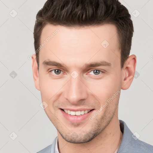 Joyful white young-adult male with short  brown hair and grey eyes