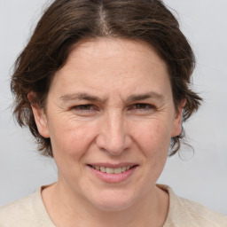 Joyful white adult female with medium  brown hair and grey eyes