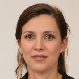 Joyful white adult female with medium  brown hair and grey eyes