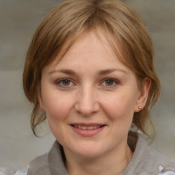 Joyful white adult female with medium  brown hair and grey eyes