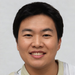 Joyful asian young-adult male with short  black hair and brown eyes