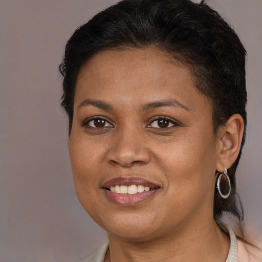 Joyful black young-adult female with short  brown hair and brown eyes
