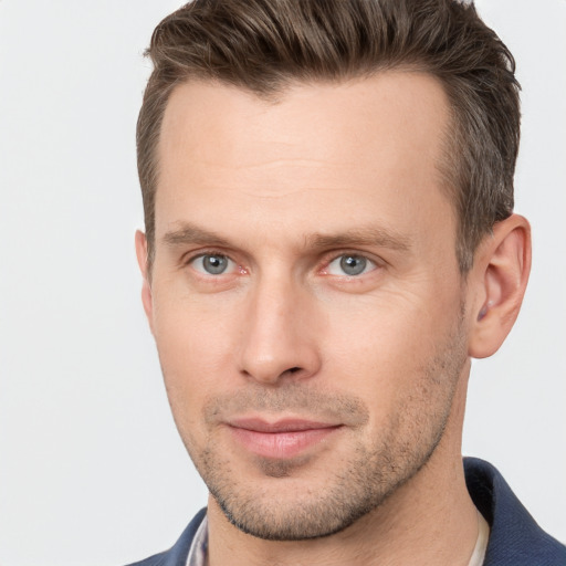 Joyful white young-adult male with short  brown hair and grey eyes