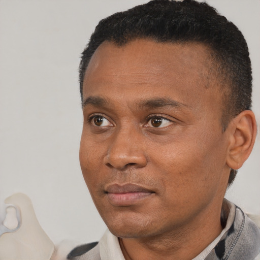 Joyful latino adult male with short  black hair and brown eyes
