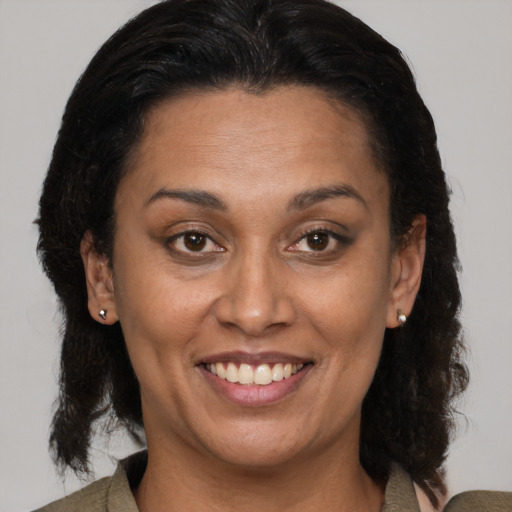 Joyful latino adult female with medium  brown hair and brown eyes