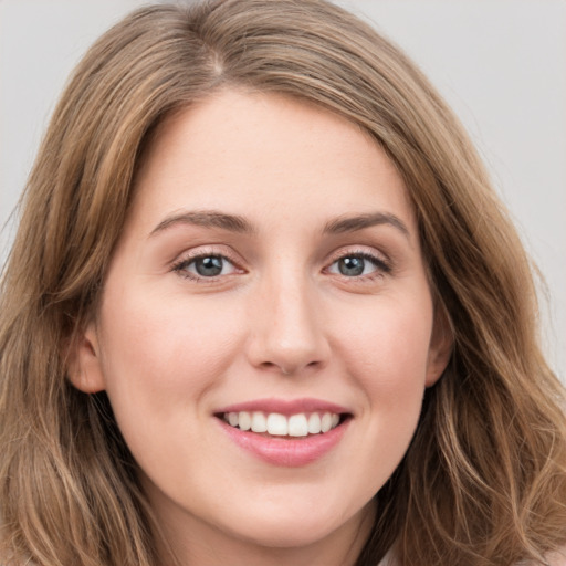 Joyful white young-adult female with long  brown hair and green eyes