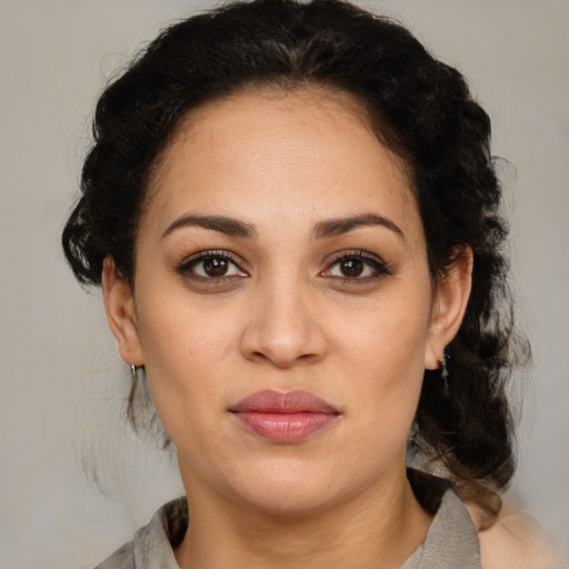 Joyful latino adult female with medium  brown hair and brown eyes