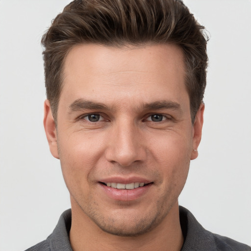 Joyful white young-adult male with short  brown hair and grey eyes