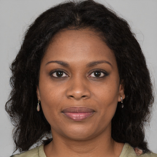 Joyful black young-adult female with long  brown hair and brown eyes