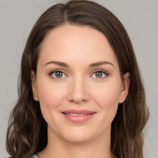 Joyful white young-adult female with long  brown hair and green eyes