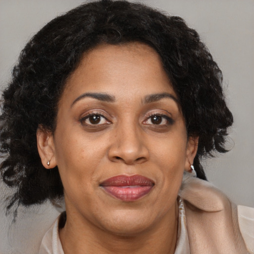 Joyful black adult female with medium  brown hair and brown eyes