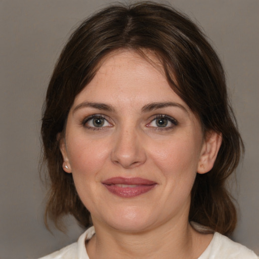 Joyful white adult female with medium  brown hair and brown eyes