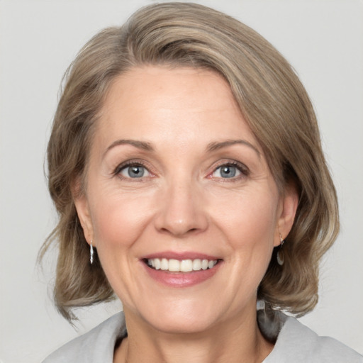 Joyful white adult female with medium  brown hair and grey eyes