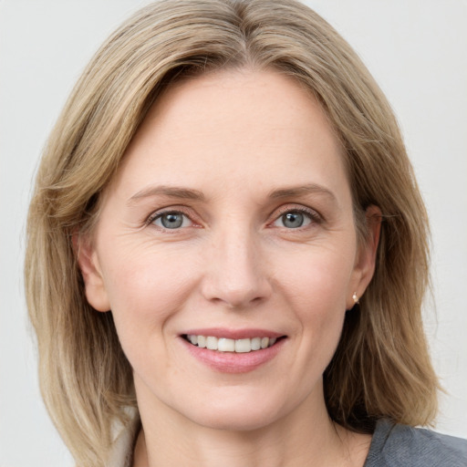 Joyful white adult female with medium  brown hair and blue eyes