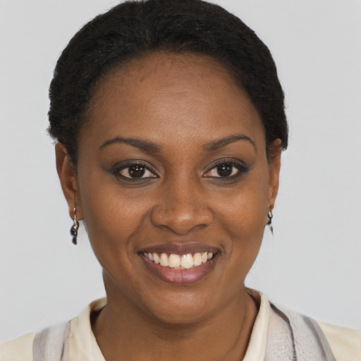 Joyful black young-adult female with short  brown hair and brown eyes