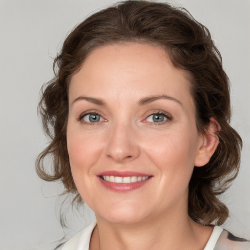 Joyful white young-adult female with medium  brown hair and blue eyes