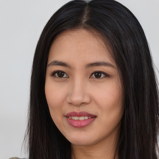 Joyful asian young-adult female with long  brown hair and brown eyes