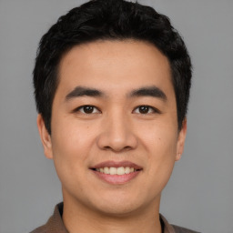 Joyful asian young-adult male with short  black hair and brown eyes