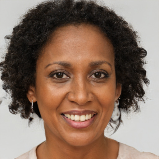 Joyful black adult female with medium  brown hair and brown eyes