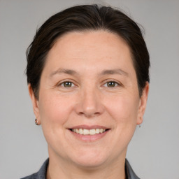 Joyful white adult female with medium  brown hair and grey eyes