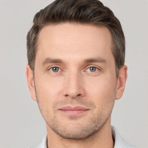 Joyful white young-adult male with short  brown hair and grey eyes