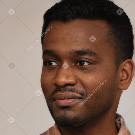 Joyful black young-adult male with short  black hair and brown eyes