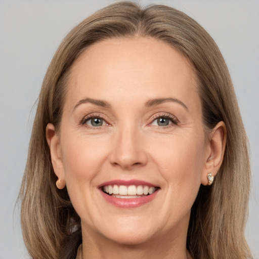 Joyful white adult female with long  brown hair and grey eyes