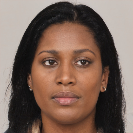 Joyful black young-adult female with long  black hair and brown eyes
