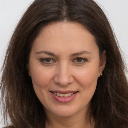 Joyful white adult female with long  brown hair and brown eyes