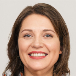 Joyful white young-adult female with medium  brown hair and green eyes