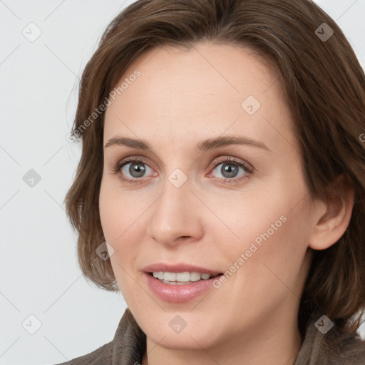 Joyful white young-adult female with medium  brown hair and grey eyes