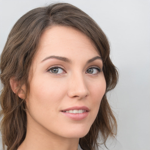 Joyful white young-adult female with long  brown hair and blue eyes